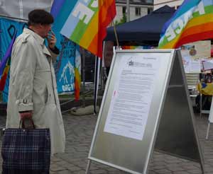 Ein Herr liest einen Text am Infostand des Friedensplenums